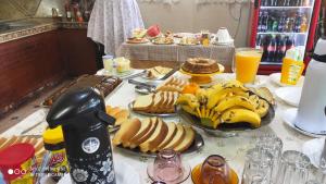a table topped with plates of bananas and other food at Pousada da Iza in Itatiaia