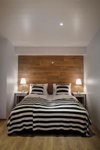 a bedroom with a large black and white striped bed at Thoristun Apartments in Selfoss