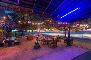a restaurant on the beach with people sitting at tables at Klongdao Sunset Villa in Ko Lanta