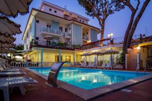 a hotel with a swimming pool in front of a building at Hotel Villa dei Fiori - sul mare con piscina in Rimini