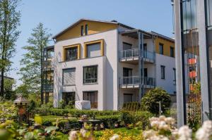 ツィノヴィッツにあるFewo 2-5 Sonnenscheinの庭園を正面に望むアパートメントビル
