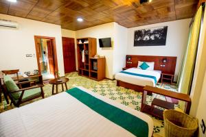 a hotel room with two beds and a desk at Sunbird Garden Resort in Sihanoukville