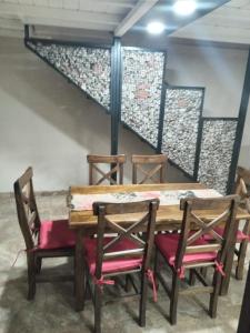 einem Holztisch mit zwei Stühlen und einer Treppe in der Unterkunft Cabañas Doña Irma in San Rafael