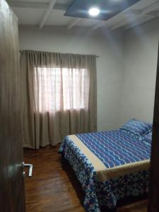 Schlafzimmer mit einem Bett und einem Fenster in der Unterkunft Cabañas Doña Irma in San Rafael