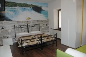 アウロンツォ・ディ・カドーレにあるAlbergo Garni Barancioのベッドルーム1室(ベッド2台付)が備わります。滝の壁画があります。