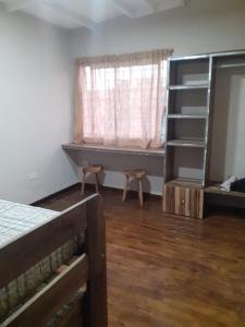 1 dormitorio con cama, ventana y estante en Cabañas Doña Irma, en San Rafael