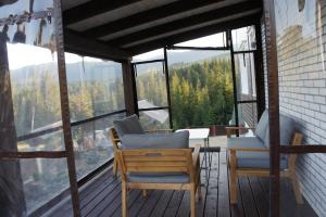 2 Stühle und ein Tisch auf einem Balkon mit Aussicht in der Unterkunft UnderДіл in Krivopolʼye