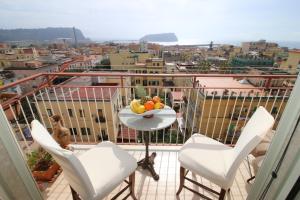 uma varanda com uma mesa e cadeiras e uma taça de fruta em Sibilla appartamento em Nápoles