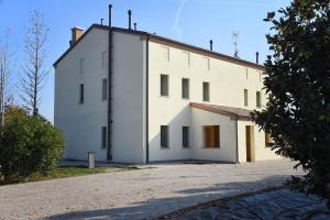 un grande edificio bianco con molte finestre di Agriturismo Corte Benetti a Rovigo