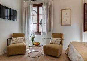 1 dormitorio con 2 sillas, 1 mesa y 1 cama en Ca’s Cuscanti, en Sóller