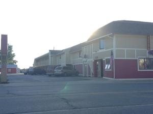 un bâtiment avec une voiture garée sur un parking dans l'établissement Downtown Motel, à Gaylord