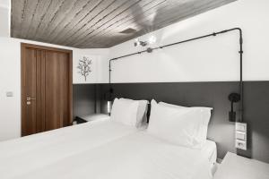 ein Schlafzimmer mit einem großen weißen Bett mit weißen Kissen in der Unterkunft ATHENIAN VIEW LOFT in Athen
