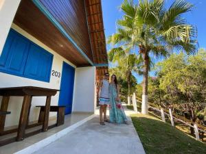 a man and woman standing outside of a building at Tijota Hotel Fazenda in Ipatinga