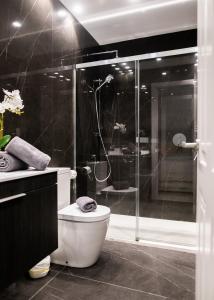 een badkamer met een douche, een toilet en een glazen douche bij innCádizCASA SEÑORIAL DE 1790 in Cádiz