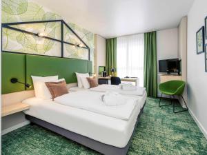Habitación de hotel con 2 camas y TV en Mercure Hotel Hannover Mitte, en Hannover
