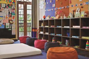 Habitación infantil con cama, sillas y estanterías en Grand Hyatt Goa, en Bambolim