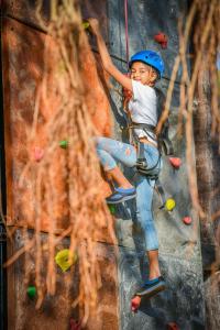 a young boy is climbing a rock wall at Grand Hyatt Goa in Bambolim