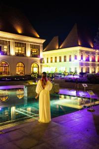 a woman standing in front of a large swimming pool at Grand Hyatt Goa in Bambolim