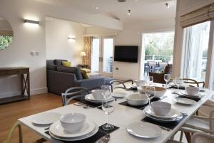 a dining room with a table with plates and wine glasses at Scout on the Water in South Cerney