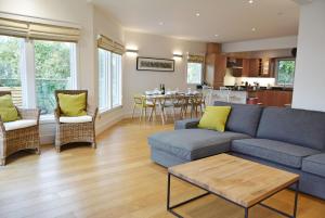 a living room with a couch and a dining room at Scout on the Water in South Cerney