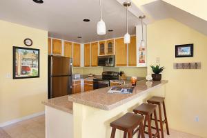 a kitchen with a large island with bar stools at Regency 321 in Koloa