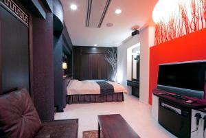 Habitación con 1 dormitorio con 1 cama y TV. en ホテル隠宿 凛 Rin, en Ōgaki