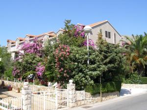 einen Zaun vor einem Haus mit rosa Blumen in der Unterkunft Guesthouse Klečak in Cavtat