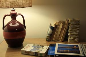 un jarrón sentado en una mesa junto a los libros en B&B Villa Giuliana, en Arnesano