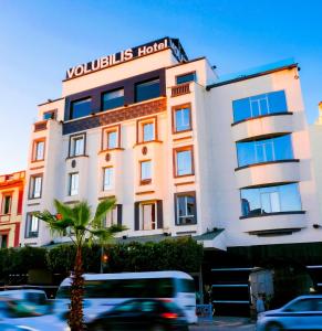 un edificio con una palma di fronte di Hôtel Volubilis Meknès a Meknès