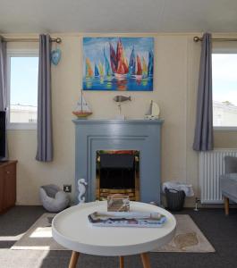ein Wohnzimmer mit einem Tisch und einem Kamin in der Unterkunft Captain's Quarters in Brixham
