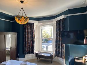 a living room with blue walls and a window at The Elizabeth House Hotel in Southampton