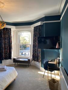 The Elizabeth House Hotel في ساوثهامبتون: غرفة نوم بسرير ومكتب ونافذة