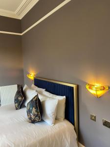 a bedroom with a bed with white sheets and pillows at The Elizabeth House Hotel in Southampton