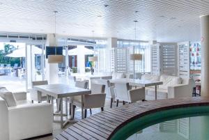a restaurant with tables and chairs and a pool at Hotel Torres da Cachoeira in Florianópolis