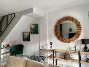 een woonkamer met een spiegel en een groene stoel bij Manilva Beach Casa de Pedro in Manilva