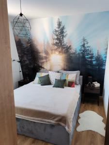 1 dormitorio con 1 cama grande y una pintura en la pared en Apartmani Kamavu en Jahorina