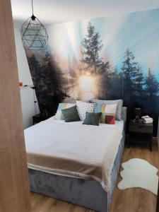 1 dormitorio con 1 cama grande y una pintura en la pared en Apartmani Kamavu en Jahorina