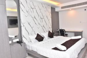 a bedroom with a large white bed with a mirror at Sanns Tropicana in Chennai