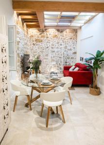 een woonkamer met een tafel en een rode bank bij innCádizCASA SEÑORIAL DE 1790 in Cádiz