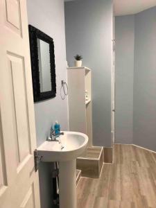 La salle de bains est pourvue d'un lavabo blanc et d'un miroir. dans l'établissement 4 bed city centre flat, à Liverpool