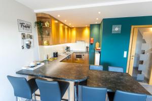 a kitchen with a large counter and blue walls at Huize Oesjoe in Bredene