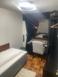een slaapkamer met een bed, een stoel en een bureau bij Einzigartige Unterkunft mit viel Extras in Kaiserslautern