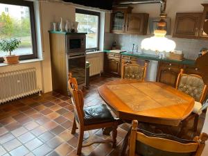 uma cozinha com uma mesa de madeira e uma sala de jantar em Einzigartige Unterkunft mit viel Extras em Kaiserslautern