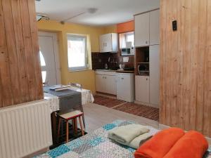 uma cozinha com armários brancos e uma mesa num quarto em Barbara Ház em Hévíz