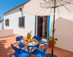 un patio con tavolo, sedie e ombrellone di Villa Marrakech by Algarve Vacation a Carvoeiro Altre 37 foto
