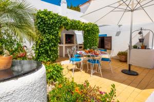 un patio con mesa, sillas y sombrilla en Villa Marrakech by Algarve Vacation, en Carvoeiro
