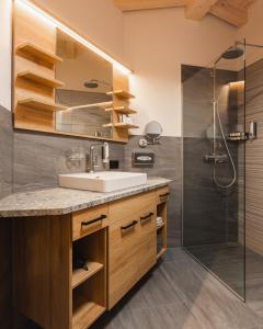 a bathroom with a sink and a shower at S'Kathrina - Appartements in Schattwald