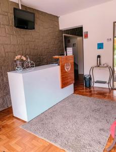Habitación con encimera y TV en la pared. en Pousada Solar Teresa, en Petrópolis
