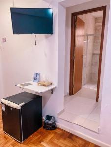 a room with a desk and a walk in shower at Pousada Solar Teresa in Petrópolis