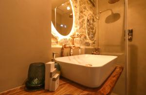 La salle de bains est pourvue d'une baignoire blanche et d'un miroir. dans l'établissement Në Kroi, à Korçë